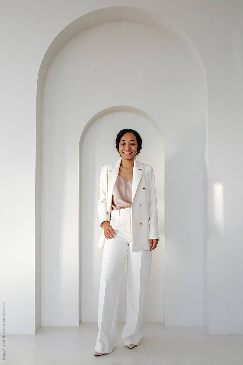 Stylish black woman in business suit standing in office