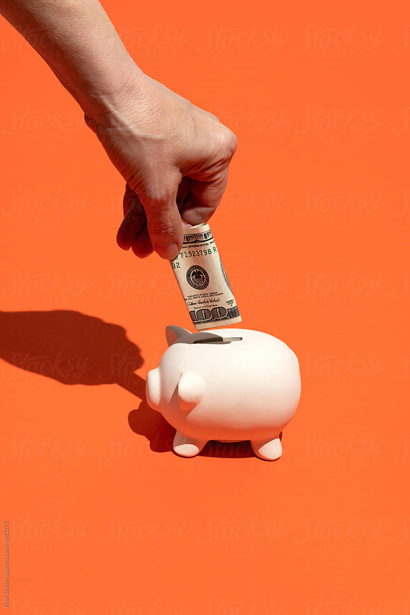 Piggy banks with a hundred dollar cash bill. Savings concept.
