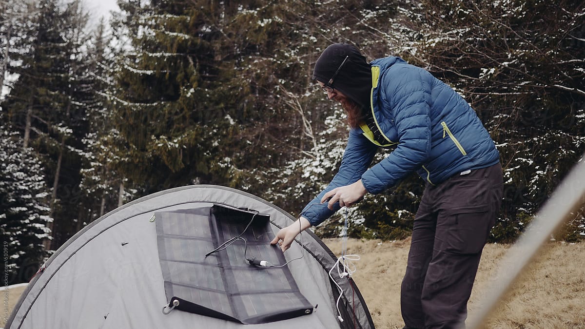 Camper putting solar panel on his tent