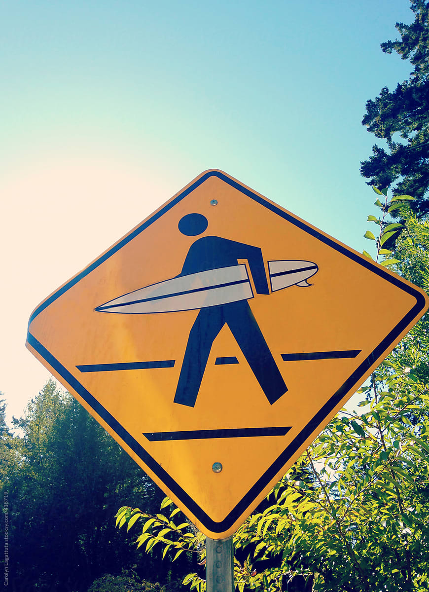 Cross walk sign with a surf board - this way to the beach