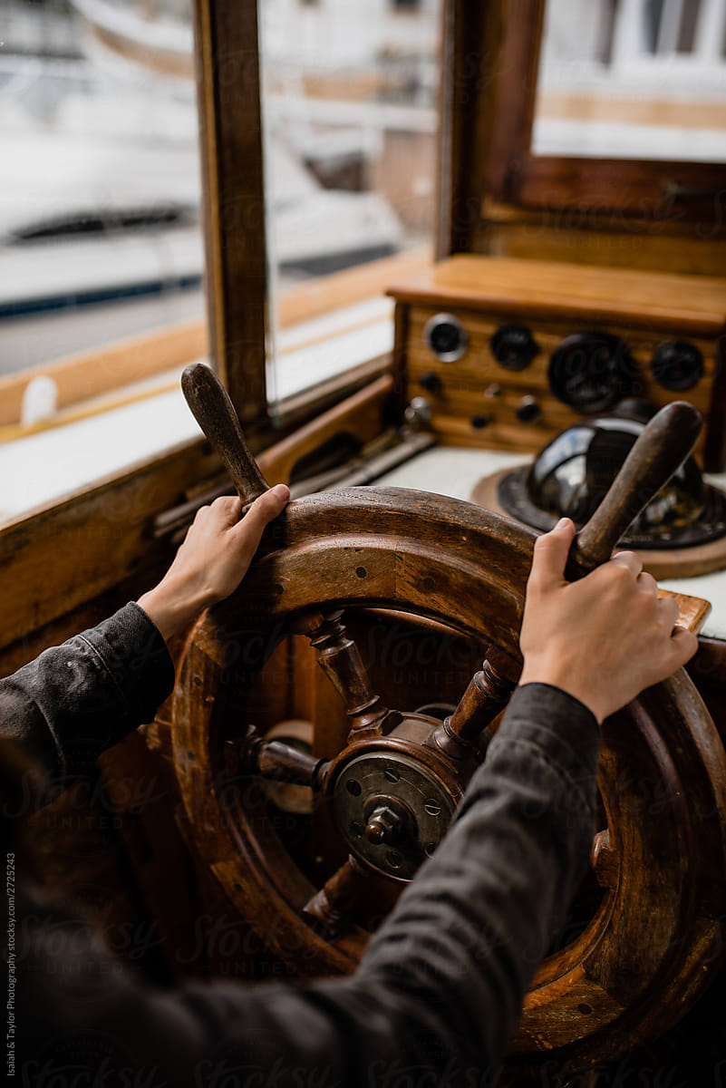 hands on helm of a boat