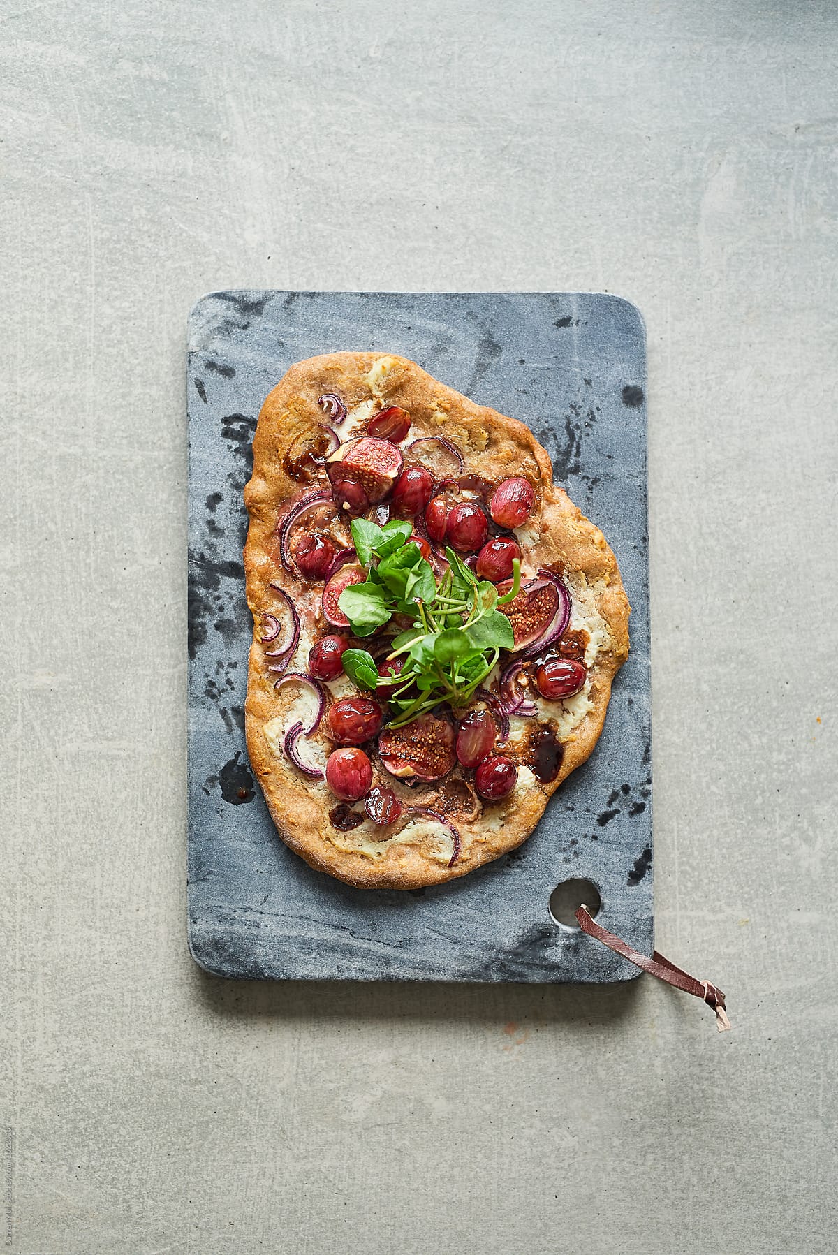 Fig and grape pizza on marble board