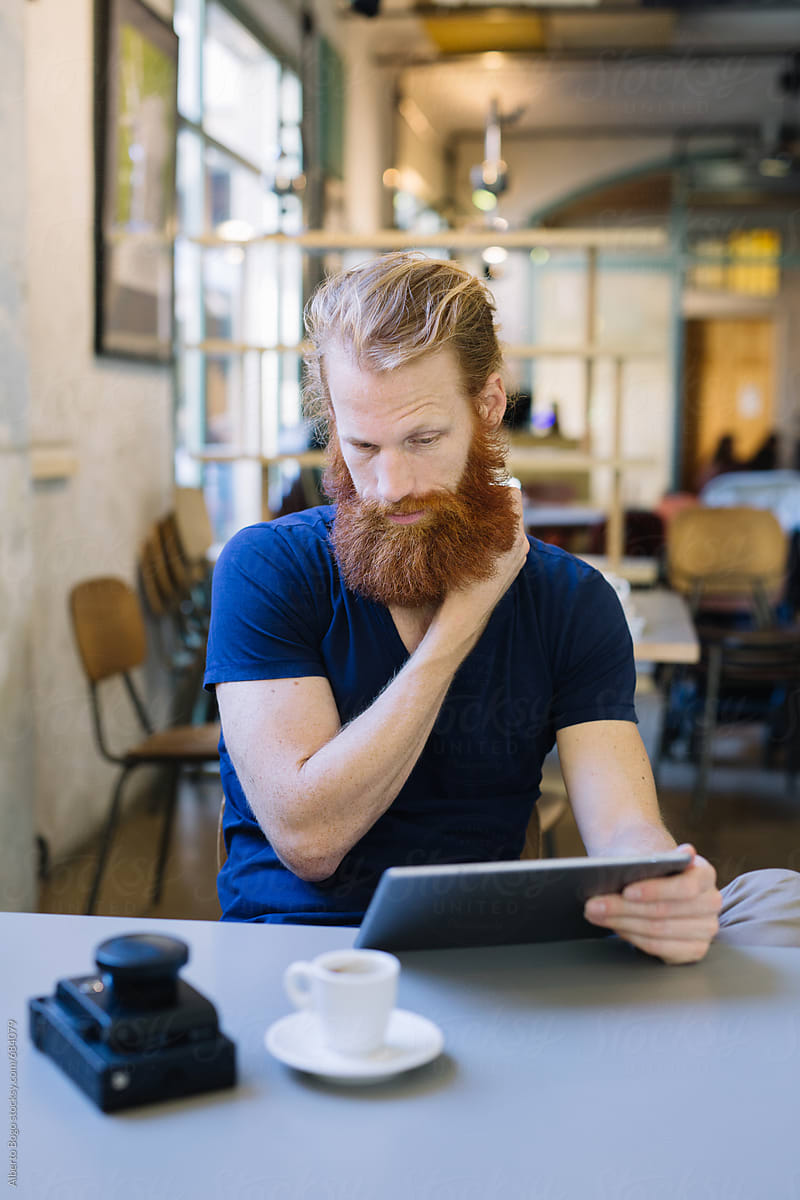 Fashionable man in a coffee shop using a tablet