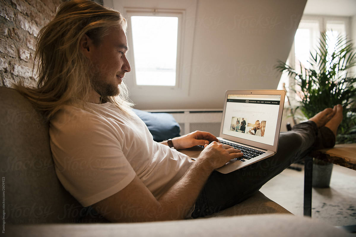 Man with long hair looking at laptop