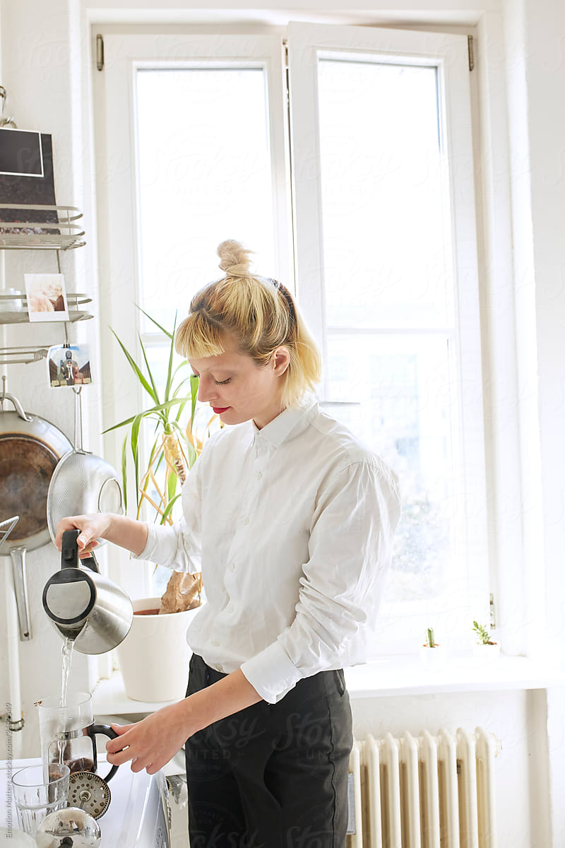 Woman pouring water into the coffee maker.