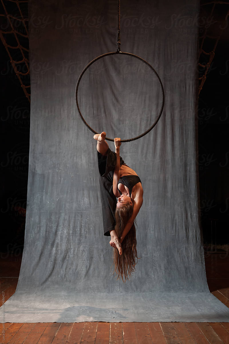 Aerial artist in a complicated pose on a Lyra or Aerial hoop