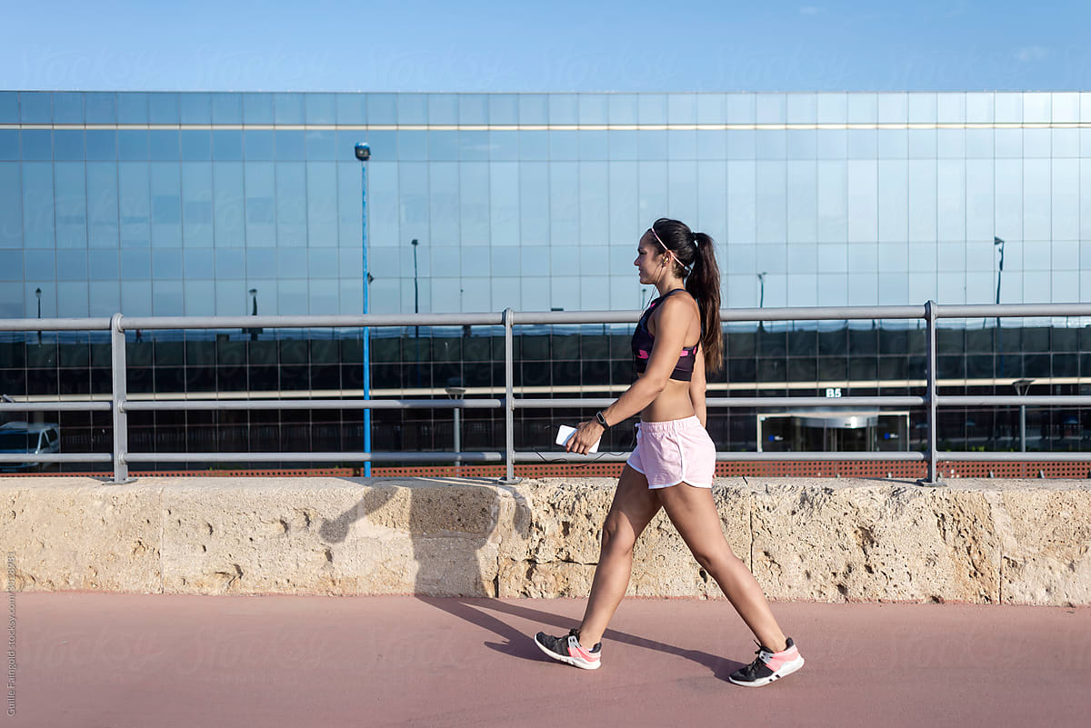 Fit girl walking in front of glass building