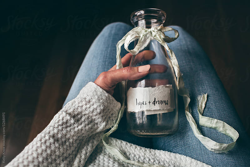 woman holding a bottle filled with hopes and dreams