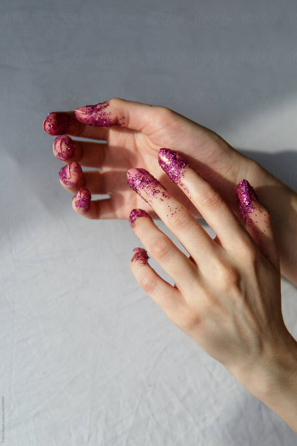 Woman hands with fingers covered in glitter
