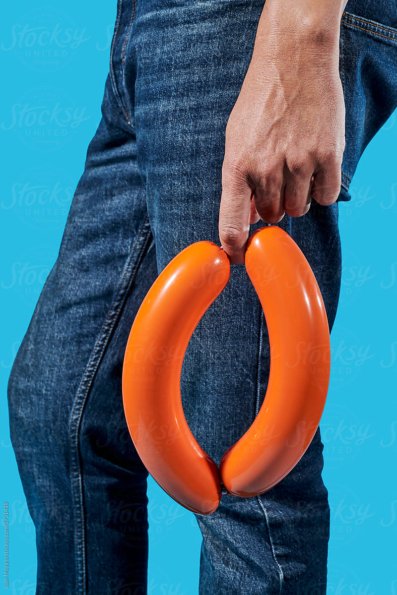 man holding a pair of sausages in his hand