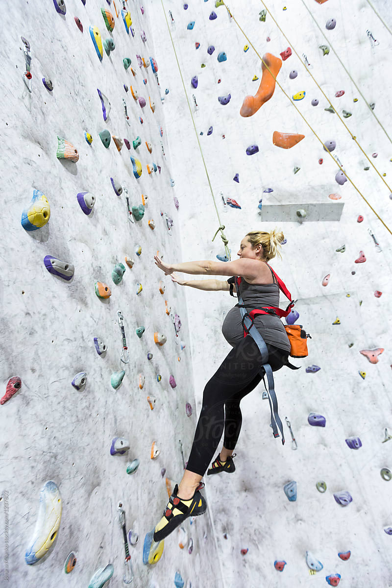 Pregnant woman rock climbing indoors
