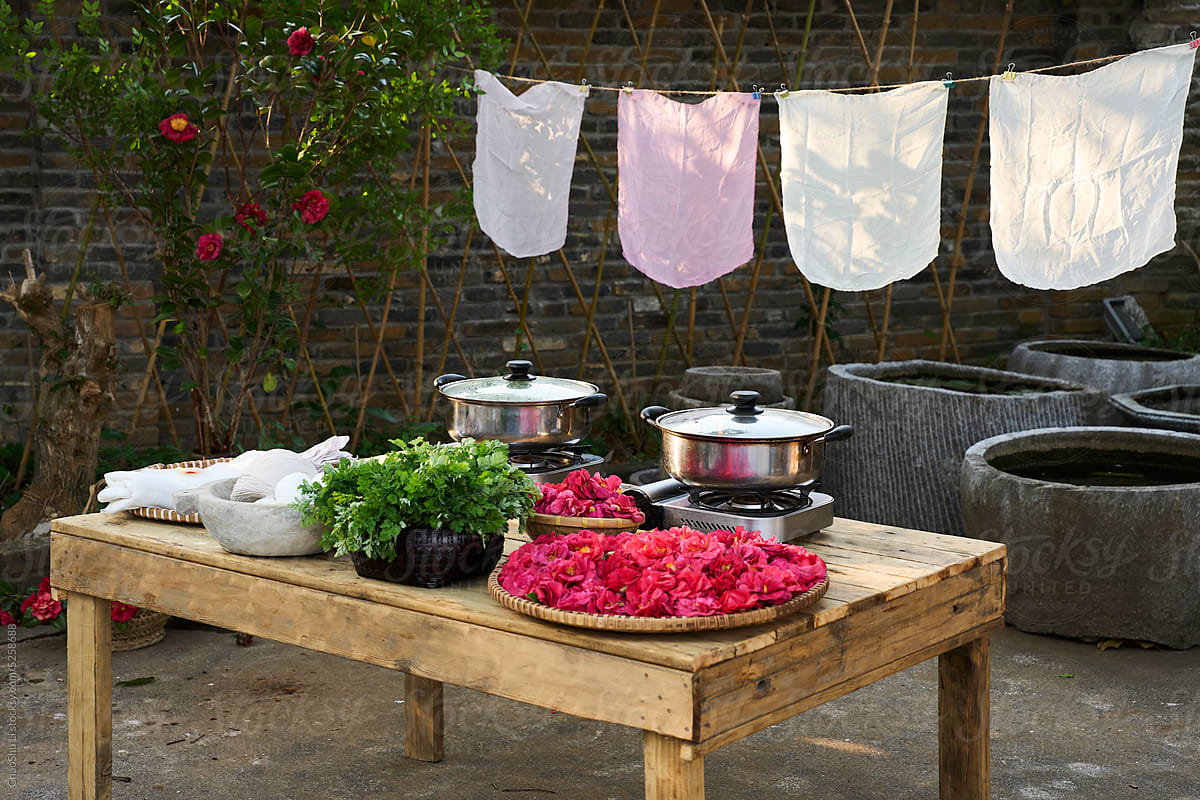 A table full of materials and tools for dyeing cloth, in the yard