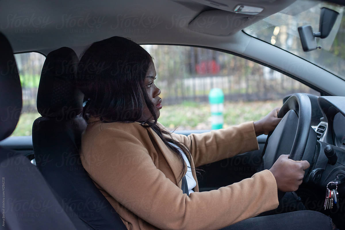 serious black woman driving a car
