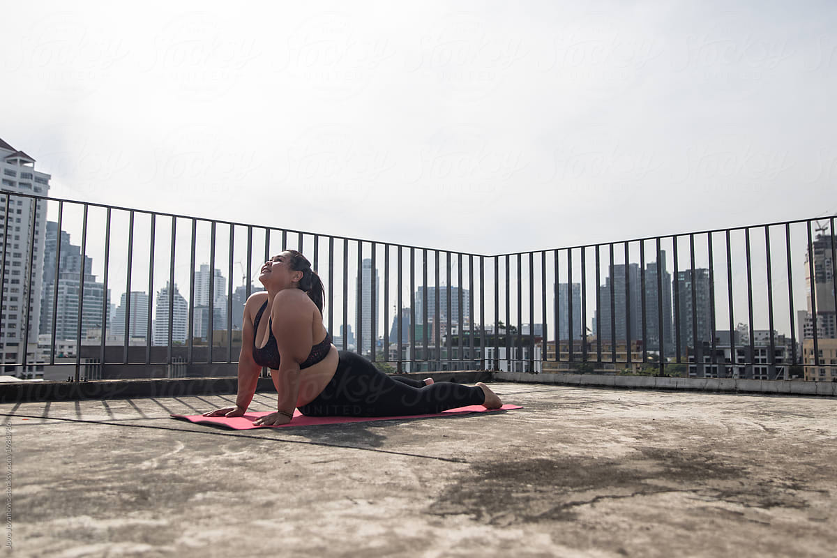 Woman Performs Cobra Pose on Rooftop