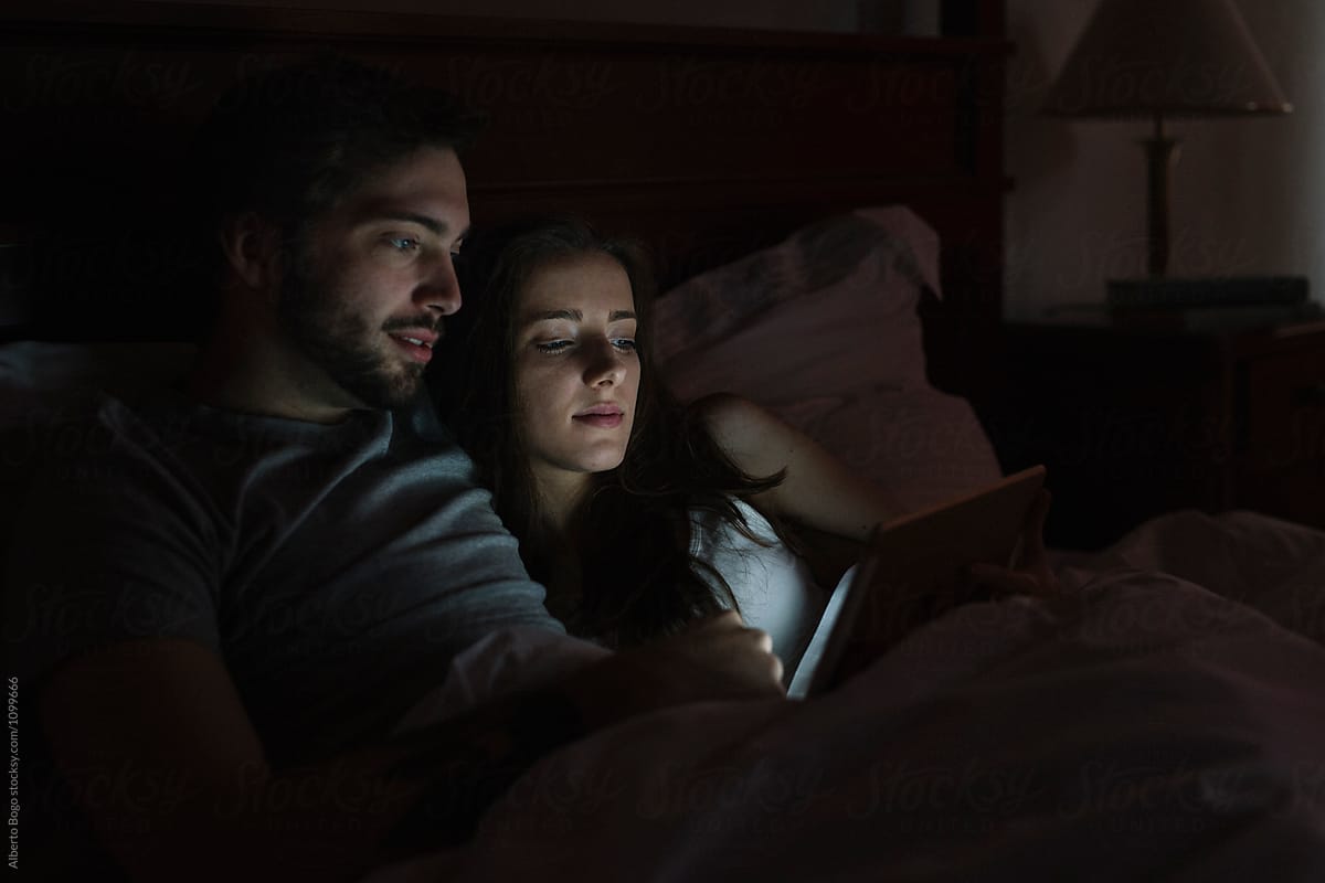 Young Couple Watching Movie On Tablet by Alberto Bogo - Couple, Watch
