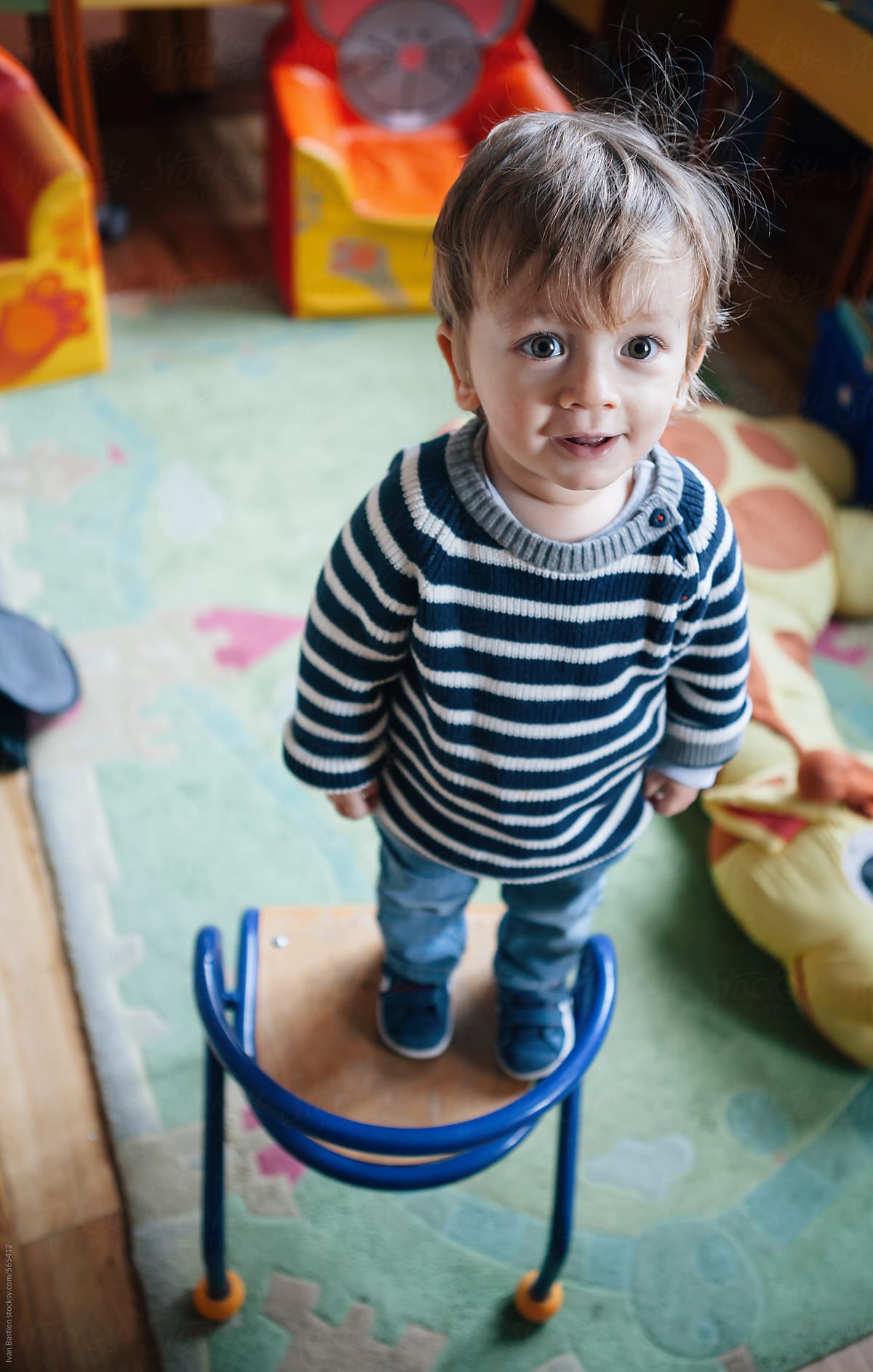 Cute baby boy standing on a chair in an old children library