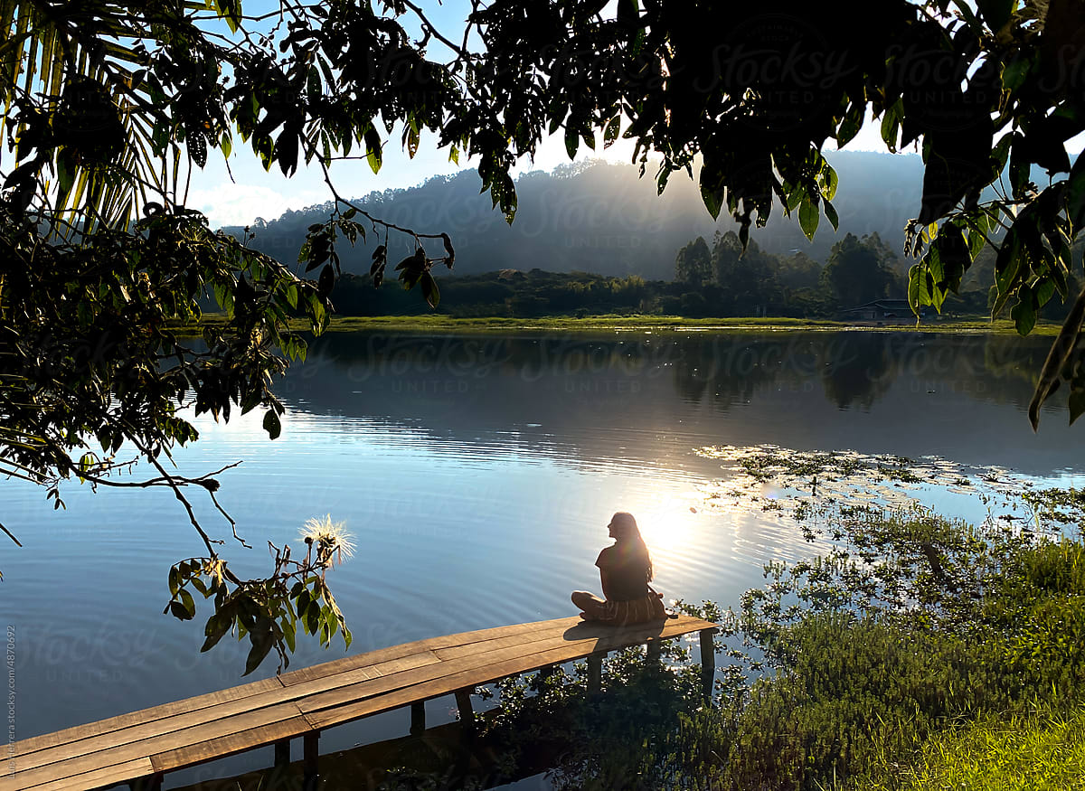 travel woman sitting by a lake