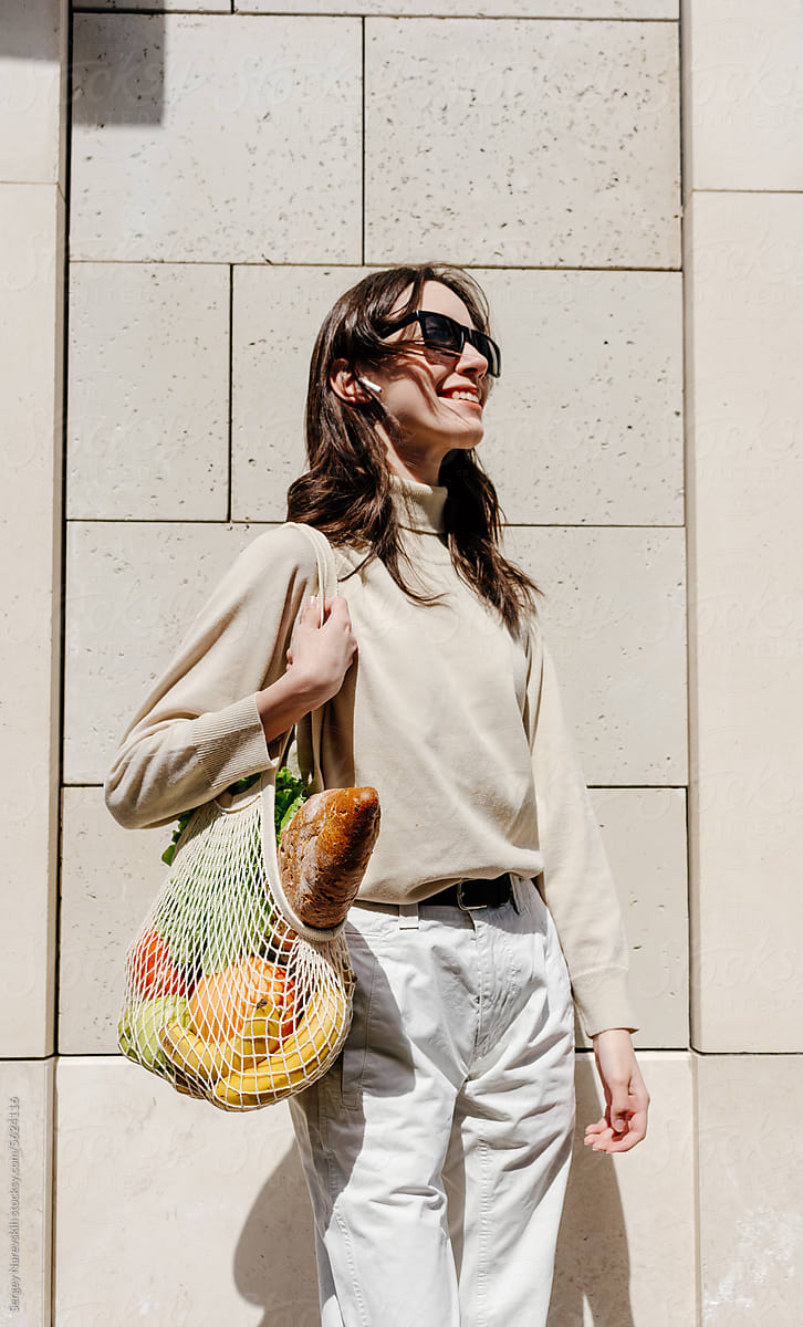 Young woman with mesh bag of groceries, zero waste