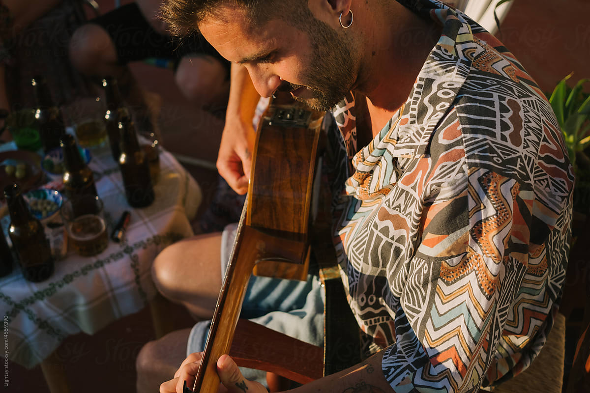 Close-up view of a man playing a guitar
