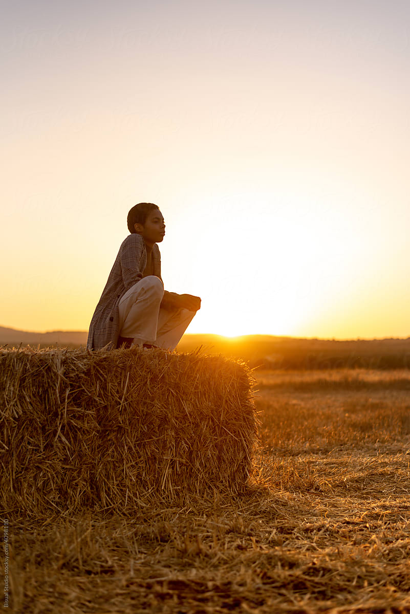 Black woman contemplating sunset in countryside