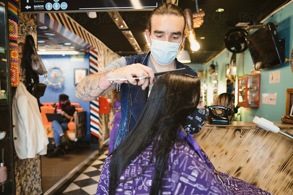 Stylist cutting teen girl’s hair at a salon