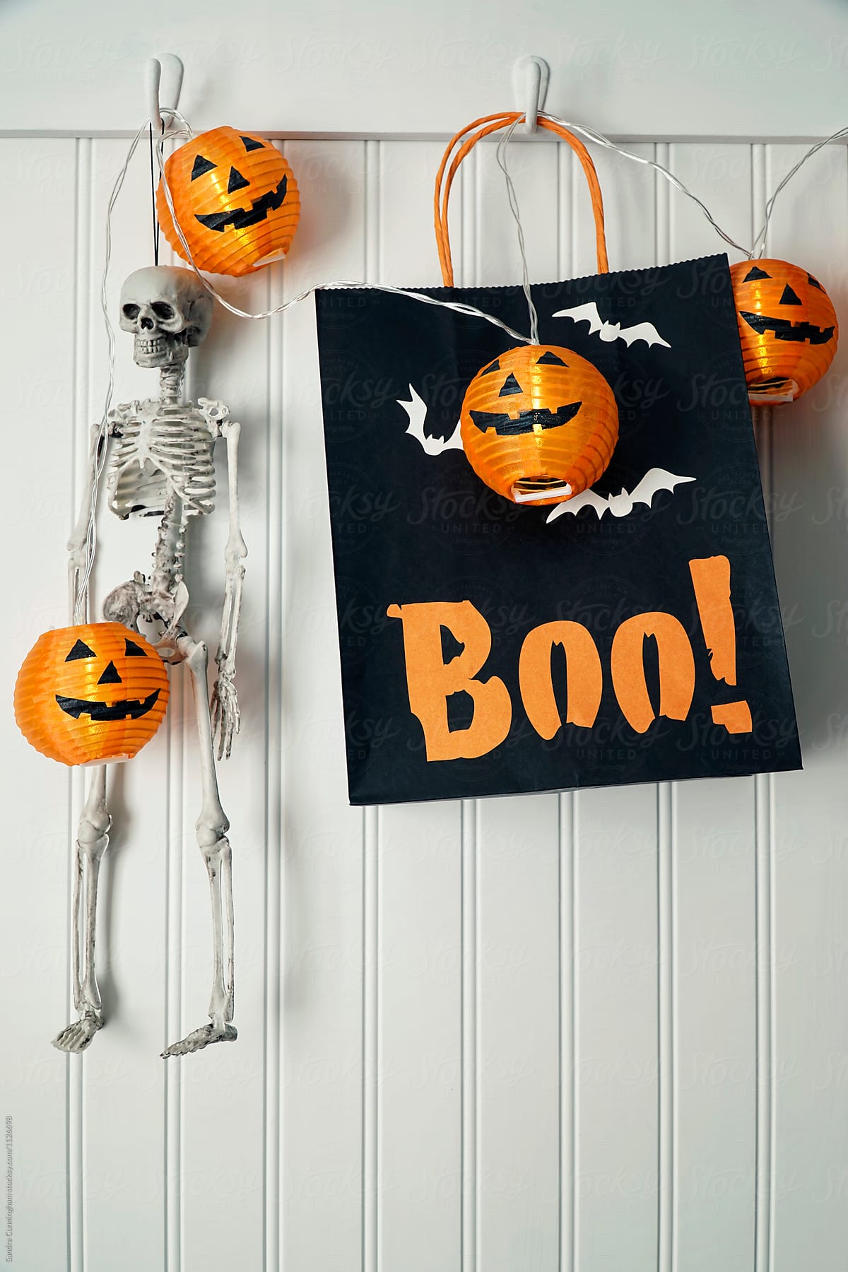 Pumpkin lights and treat bag hanging on hooks for Halloween