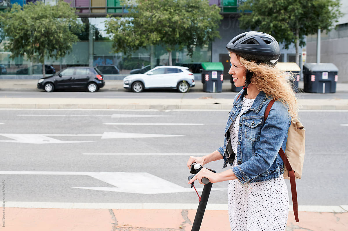 Smiling woman riding her electric scooter