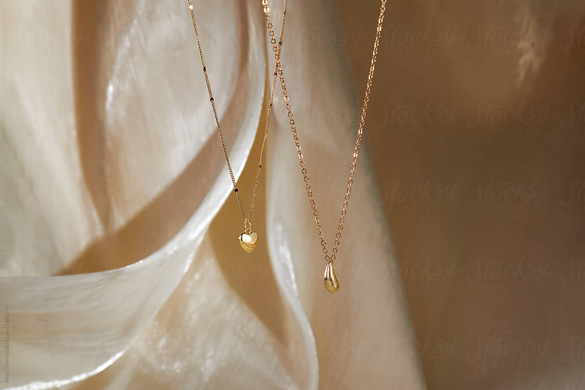 Two gold necklace with  pendants as water drop and heart.