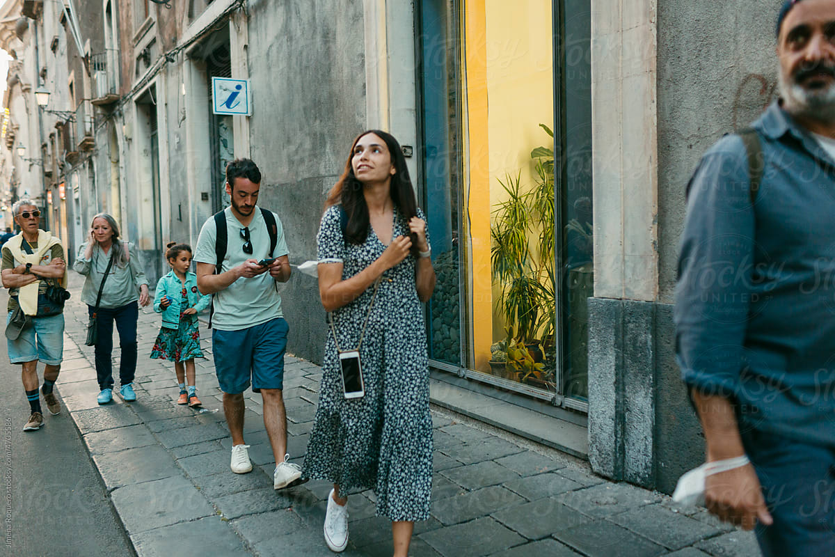 Group of people walking on Italian city street.