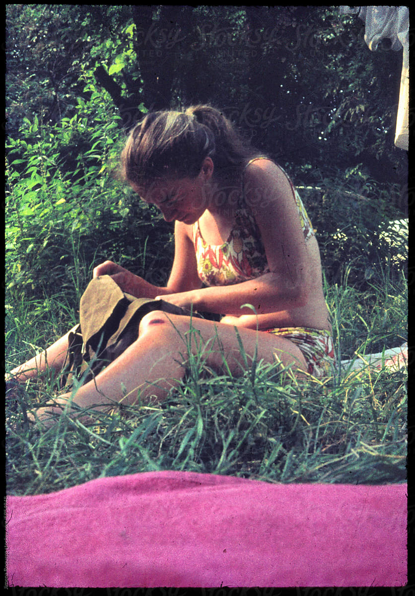 70\'s Old analog photo. Portrait of young woman sitting on the grass