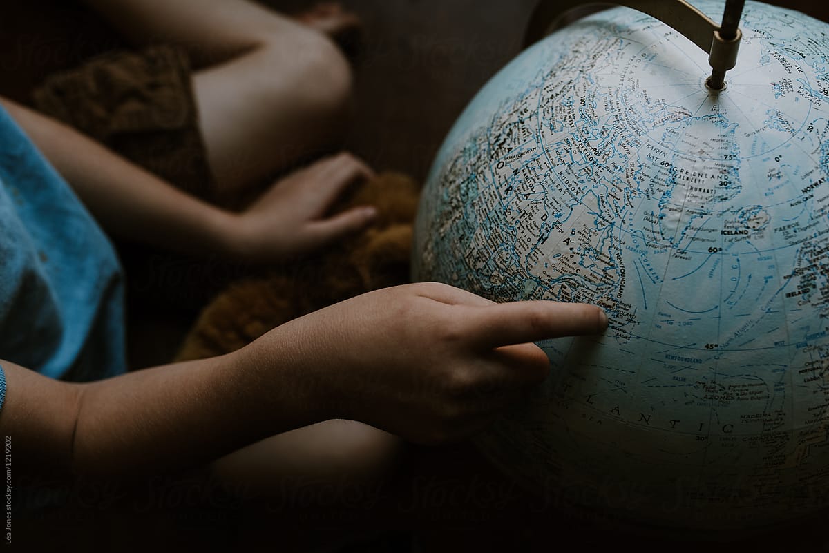 little boy looking at globe