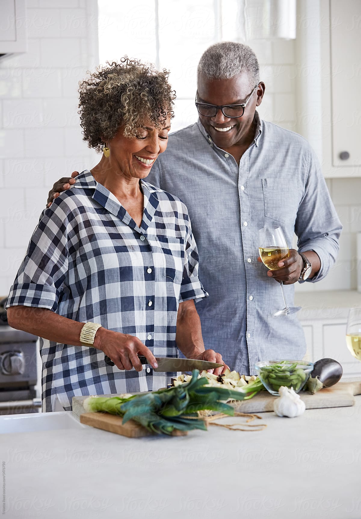 Senior African American couple chopping vegetables together in the kitchen