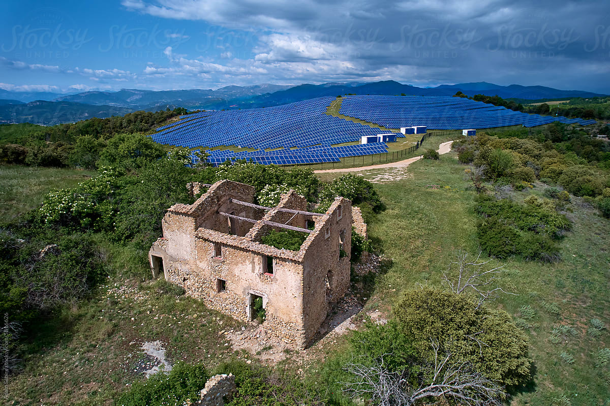 Renewable energy transition - house roof ruin and solar farm