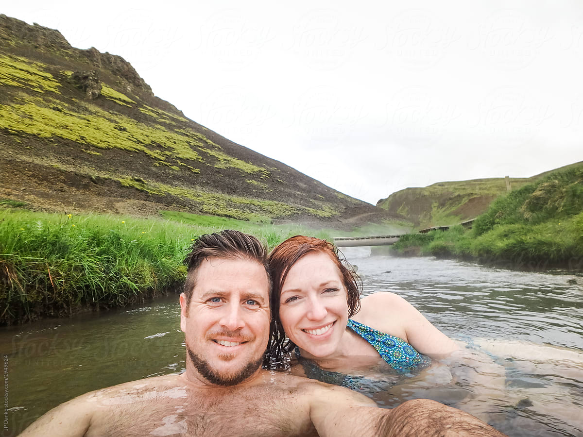 Husband and wife enjoying vacation in Iceland hot river