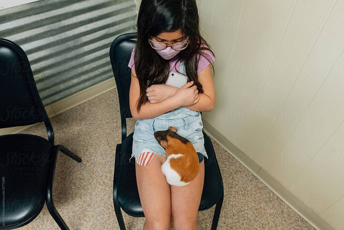 Girl and her pet waiting in the vet\'s office.