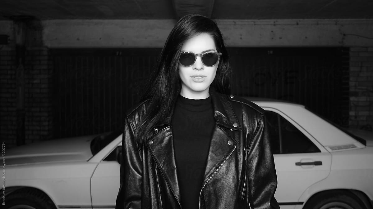 Woman In Leather Jacket Standing In Front Of The Car