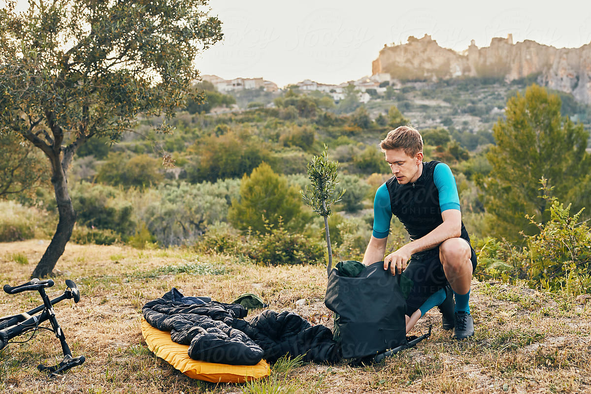 adventure cyclist unpacks for camping