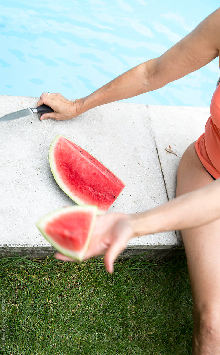 Woman\'s hand offering a watermelon slice to someone else