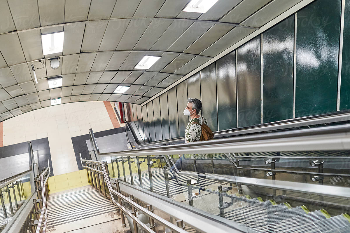 "Man In A Face Mask Standing On An Escalator" by Stocksy Contributor ...