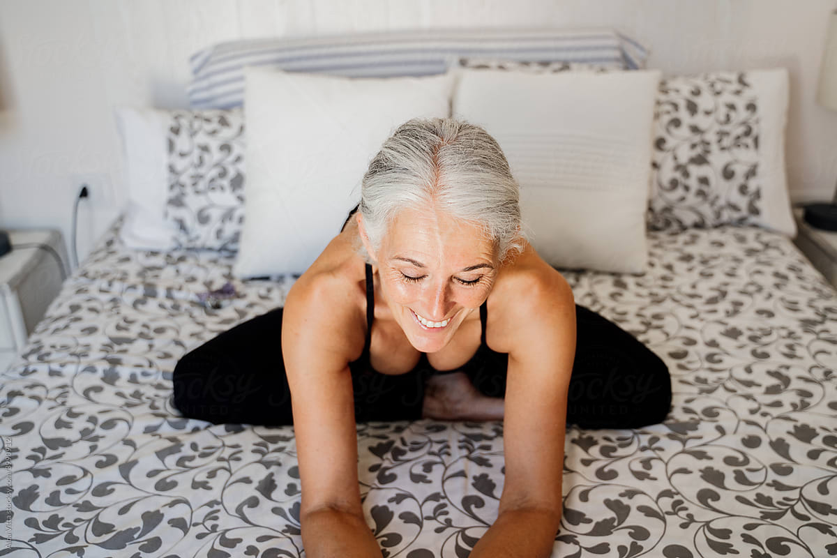 smiley Confident Mature woman sitting on bed