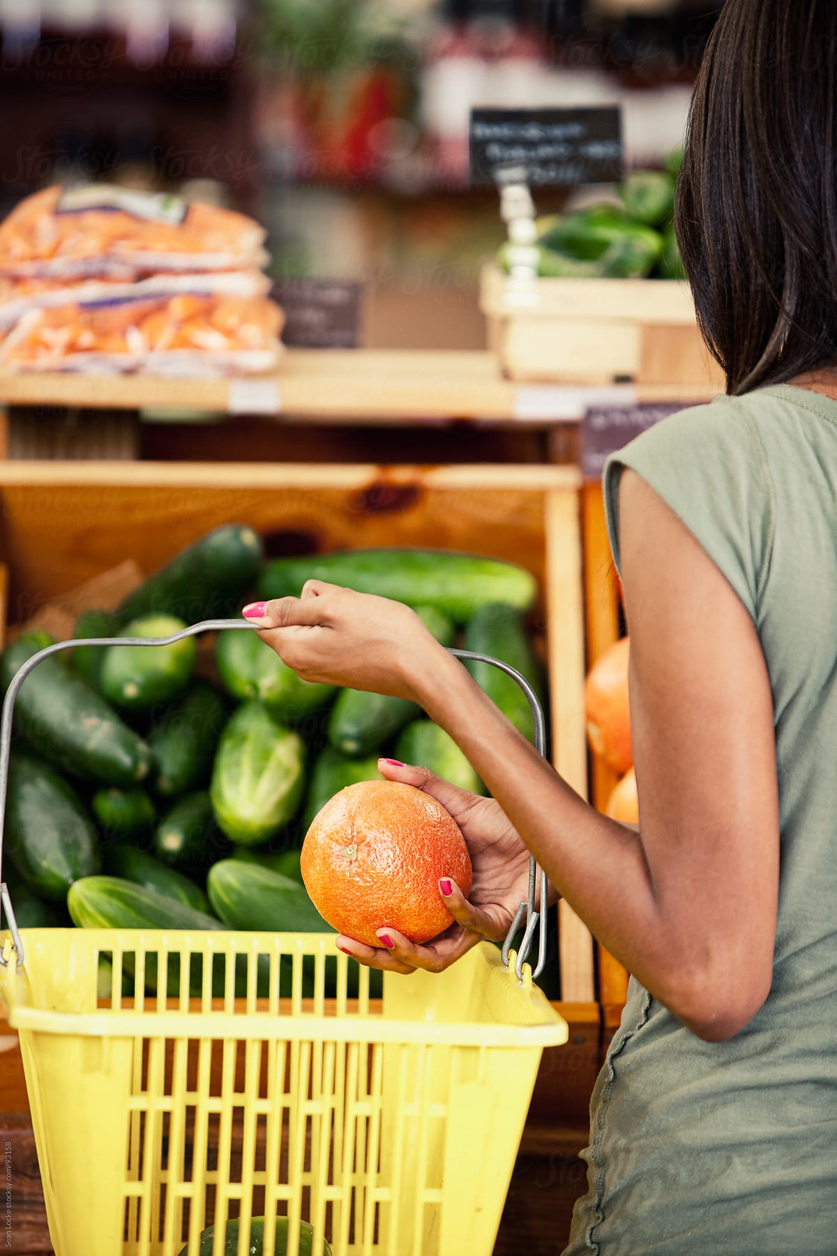 Market: Woman Puts Grapefruit Into Basket