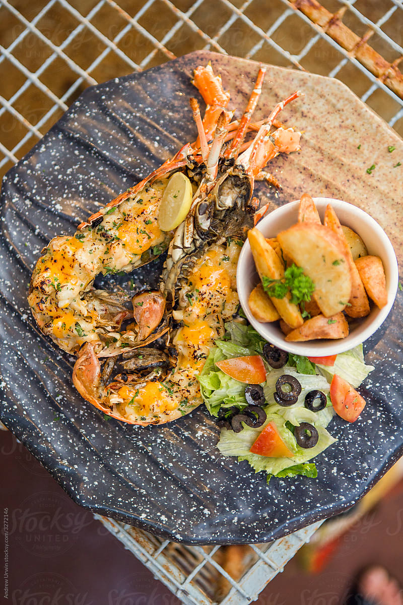 Lobster dish served in lobster shells with salad and potato wedges in Goa