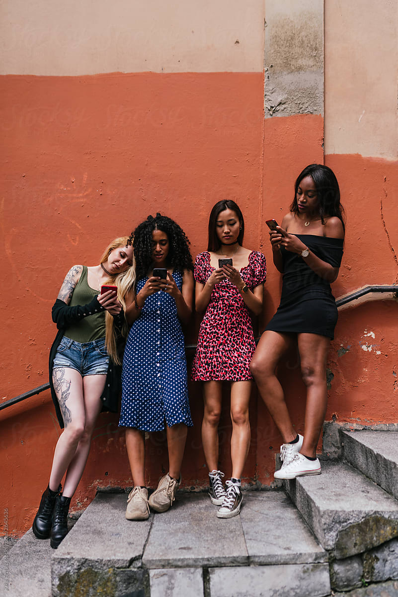 Group of multicultural girl friends using smartphone