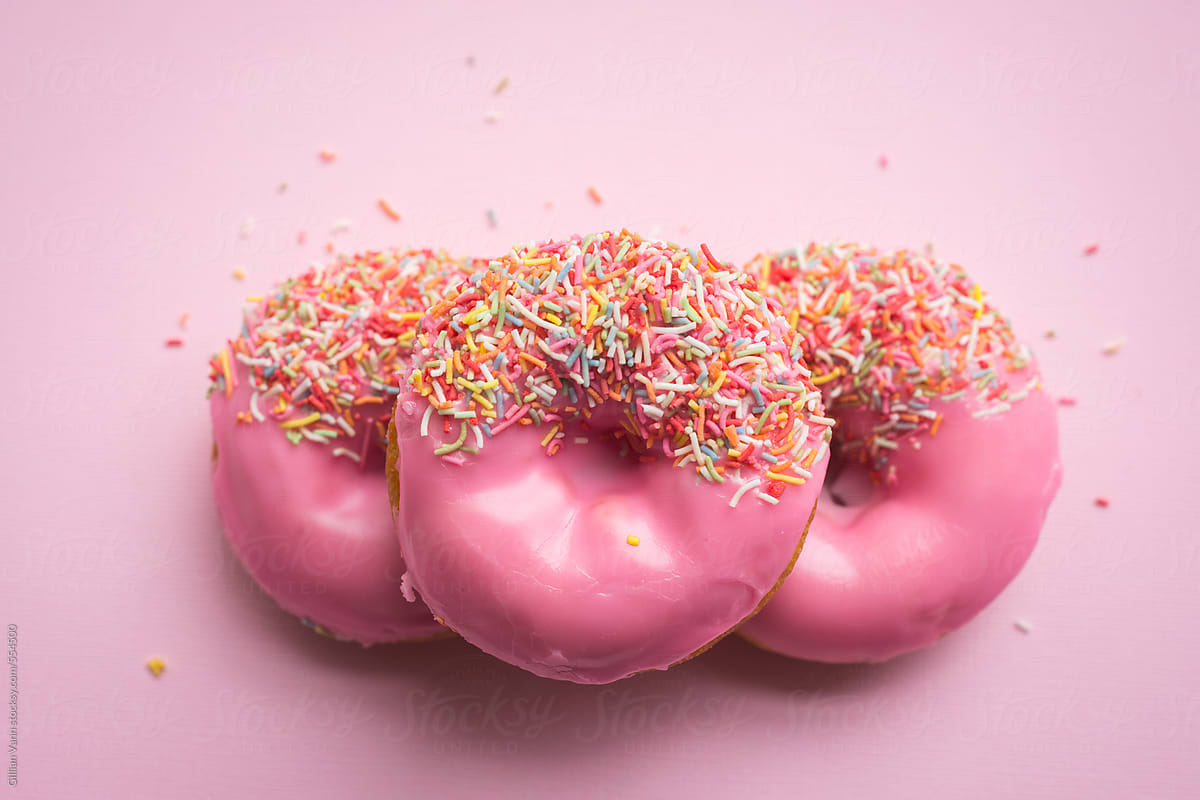 three  pink donuts on pink background