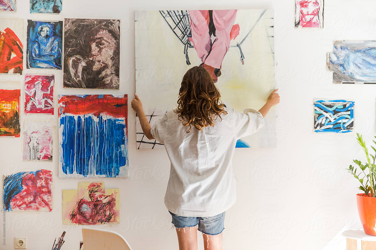 Artist placing artwork on the wall in her studio