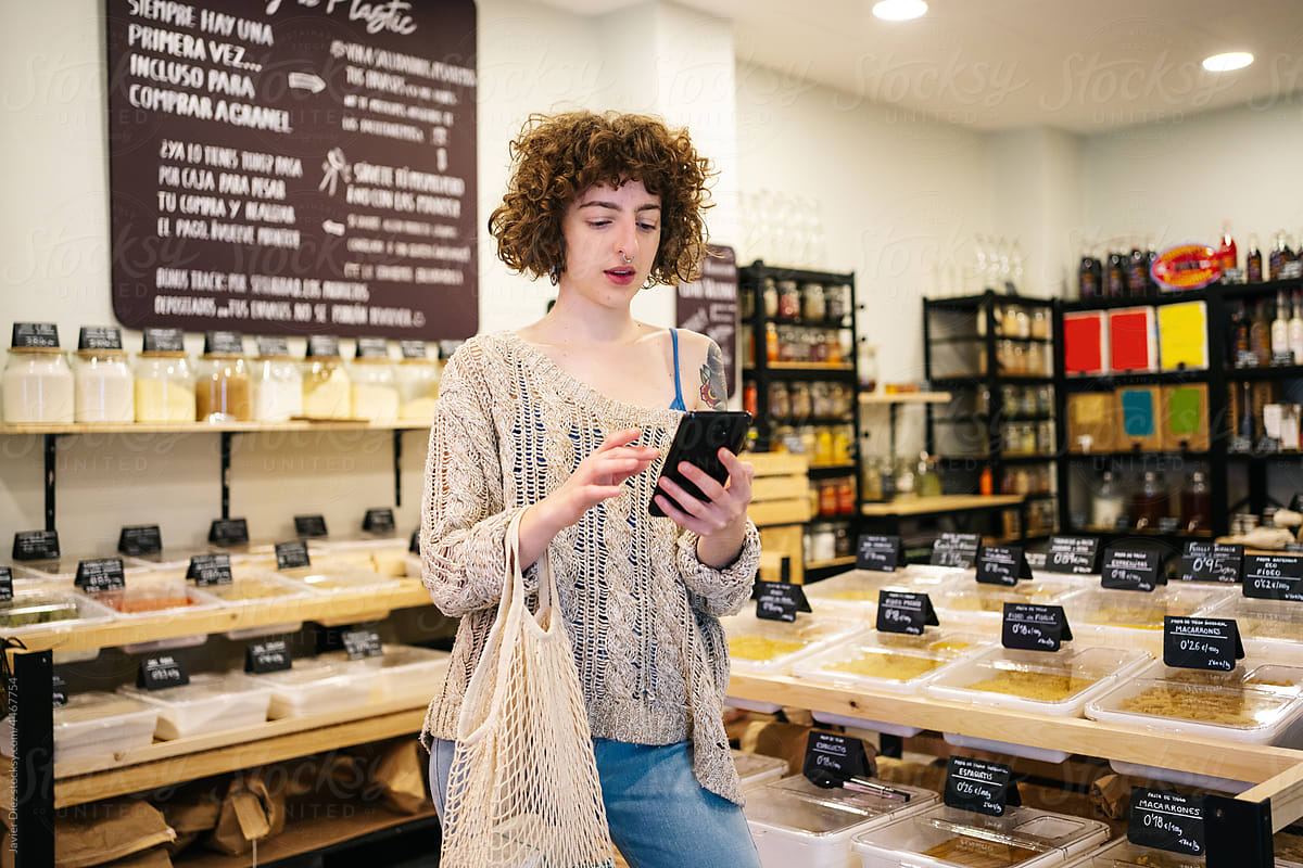 Female customer using smartphone in eco friendly shop