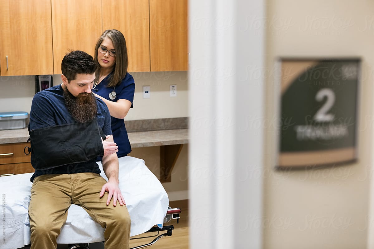 Clinic: Nurse Helps Put Sling On Patient