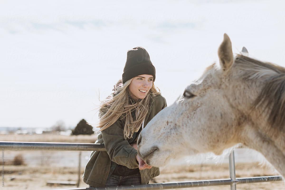 A Smiling Woman Feeds Her Horse