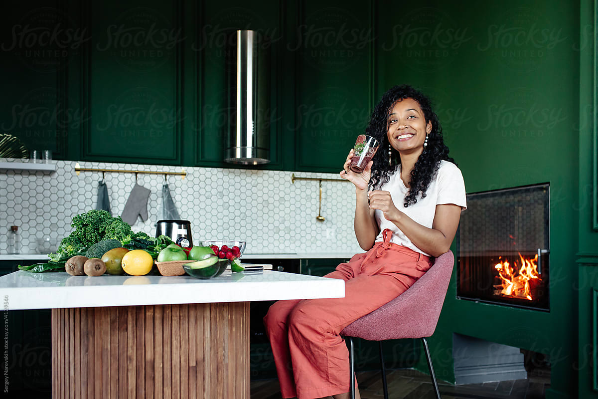 Smiling black woman with fresh smoothie