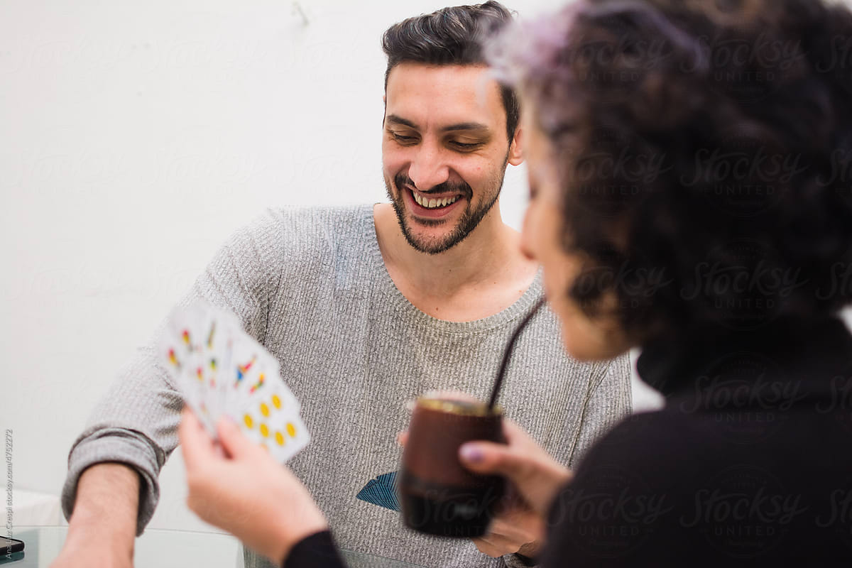 Latino couple drinking mate and playing cards